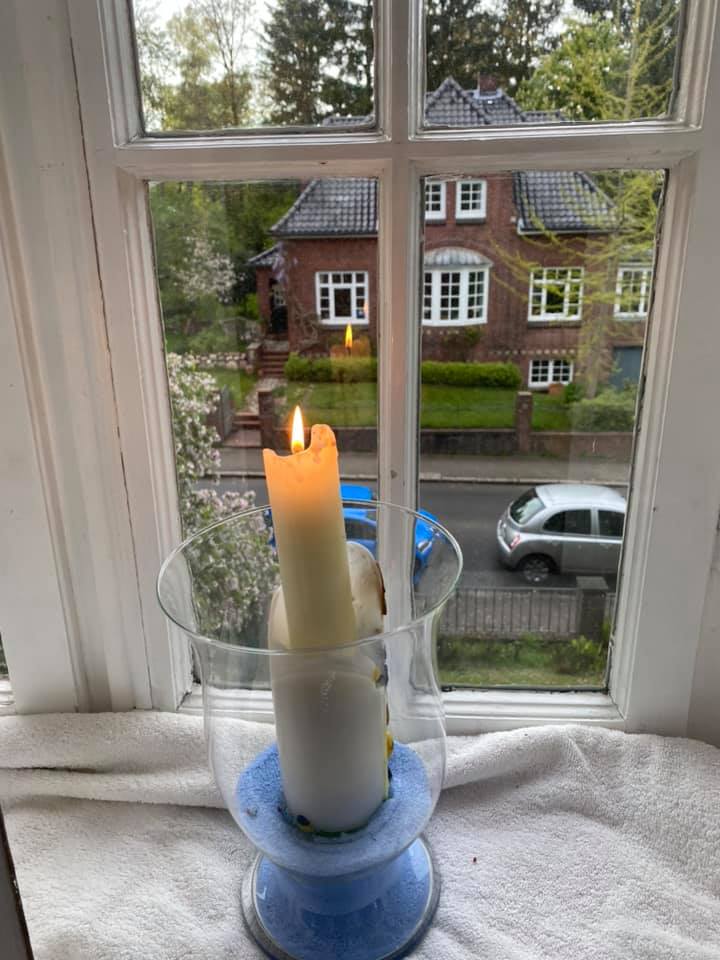 Eine Kerze steht auf einem Fensterbrett.